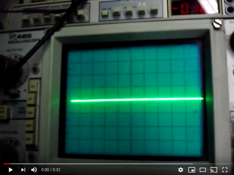 A green light is on the screen of an old oscilloscope.