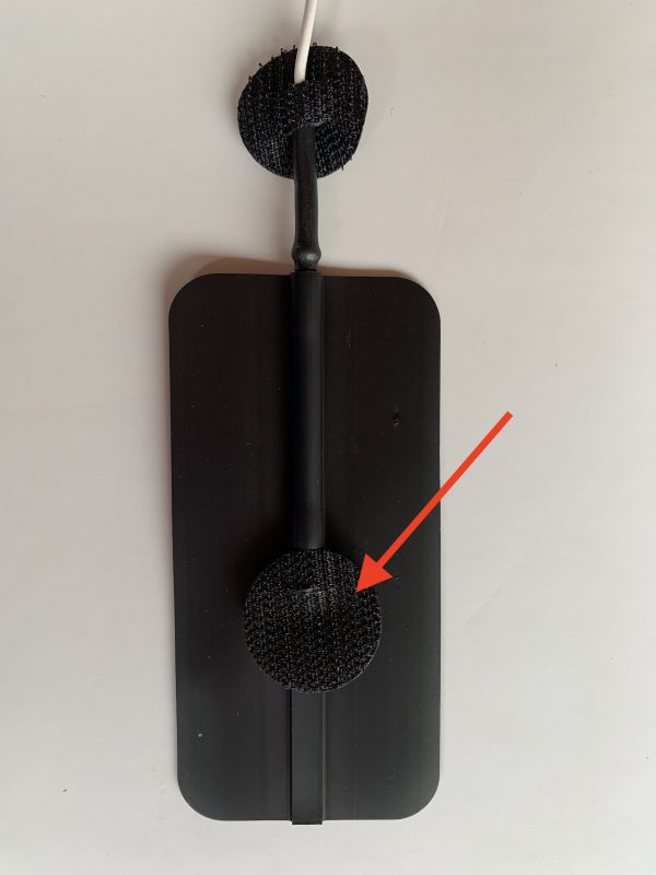 A black wall mounted shower head with an arrow pointing to the top.